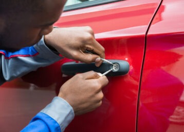 Young,Male,Mechanic,Holding,Lockpicker,To,Open,Red,Car,Door